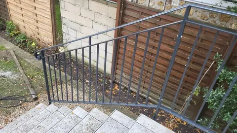 Main courante d'escalier en acier terminée par une crosse en volute