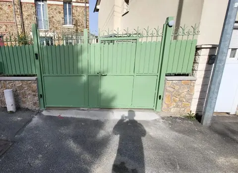 Portail et clôture en acier vert avec barreaudage festonné sur muret