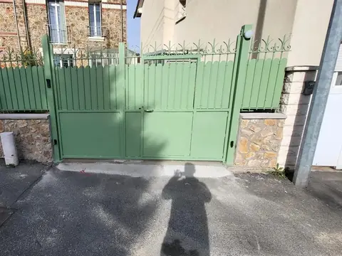 Portail et clôture en acier vert avec barreaudage festonné sur muret