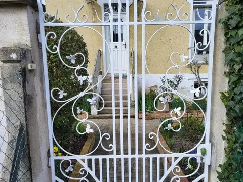 Portillon en fer forgé à volutes restauré et repeint en blanc